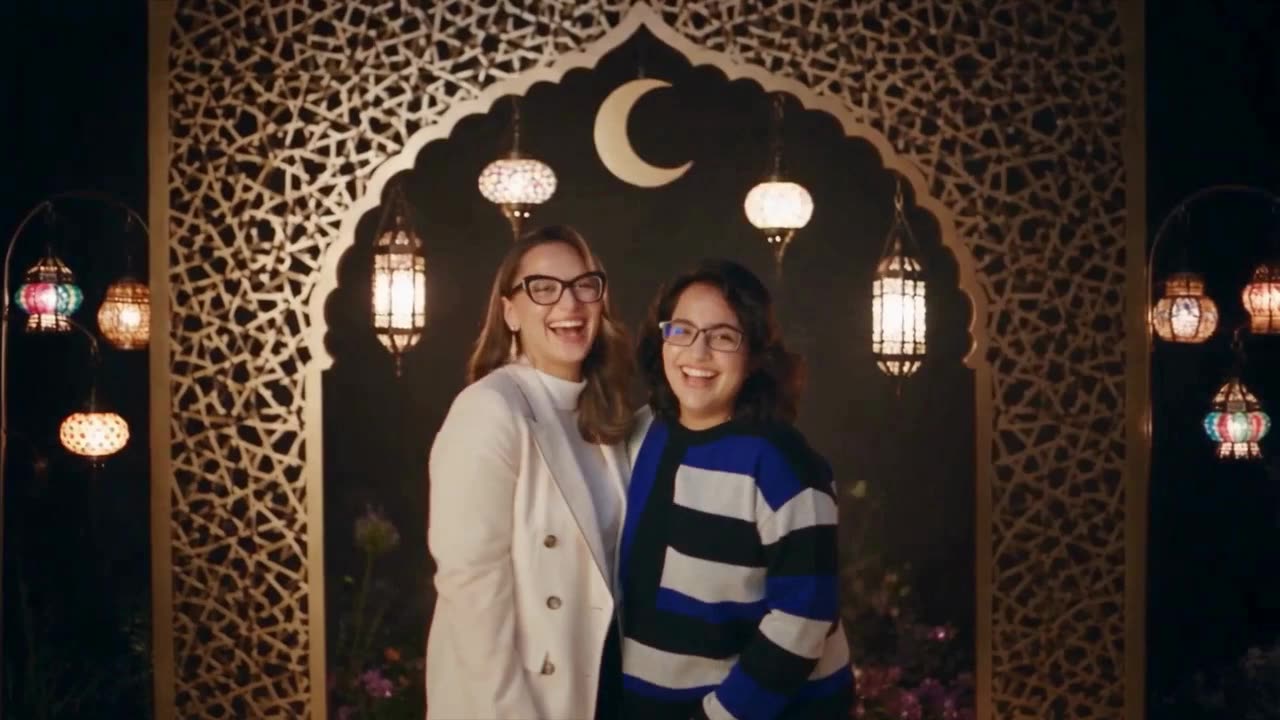 Two friends laughing beneath a golden archway